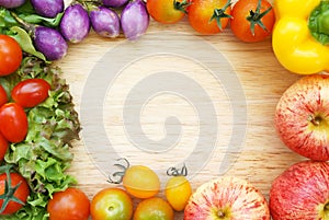 Colorful fresh organic vegetables composing a frame on a wooden chopping board.