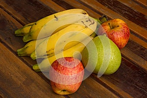 Colorful fresh summer fruits on brown wooden background, healthy organic food on table, detox vitamin nutrition for health care.