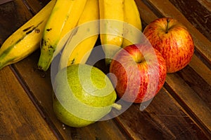 Colorful fresh summer fruits on brown wooden background, healthy organic food on table, detox vitamin nutrition for health care.