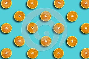 Colorful fruit pattern of Sumo mandarin fresh seet orange slices on blue background, spring, summer cocept