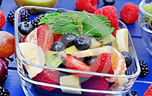 Colorful fruit salad in a transparent bowl on table