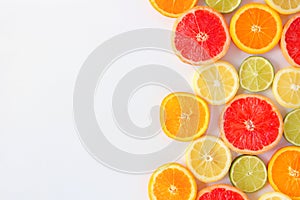 Colorful fruit side border of citrus slices, top view over a white background
