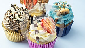 Colorful, funny and delicious muffin cupcakes collection decorated in various styles. Pastries with cream, fruits, cookies and cho