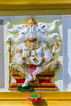 Colorful Ganesha Hindu god avatar images in stucco low relief white wall at the public Wat Samarn temple, Chachoengsao, Thailand.