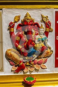 Colorful Ganesha Hindu god avatar images in stucco low relief white wall at the public Wat Samarn temple, Chachoengsao, Thailand.