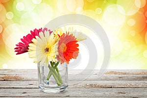 Colorful gerbera flowers on wooden table