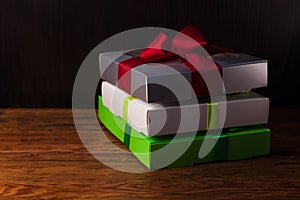 Colorful gift boxes with ribbon bows on a brown wooden background with copy space.Holidays,Christmas, New Year presents