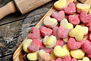 Colorful gnocchi hearts on a old table with rolling pin