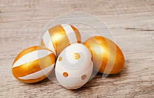 Colorful golden bright handmade painted easter eggs isolated on a wood