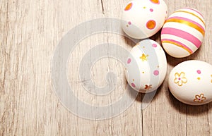 Colorful golden bright handmade painted easter eggs on a wood background