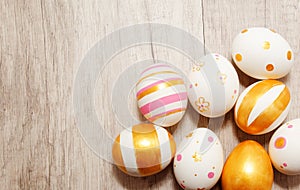 Colorful golden bright handmade painted easter eggs on a wood background