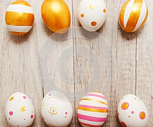 Colorful golden bright handmade painted easter eggs on a wood background