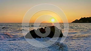 Colorful golden sunset big waves rocks beach Puerto Escondido Mexico.