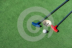 colorful golf putters with golf balls on synthetic grass