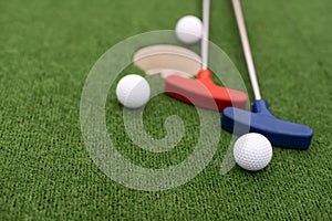 colorful golf putters with golf balls on synthetic grass