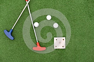 colorful golf putters with golf balls on synthetic grass