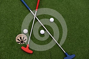 colorful golf putters with golf balls on synthetic grass