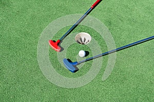 colorful golf putters with golf balls on synthetic grass