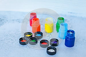 Colorful Gouache or acrylic paints in jars on white grunge background, selective focus