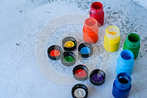 Colorful Gouache or acrylic paints in jars on white grunge background, selective focus