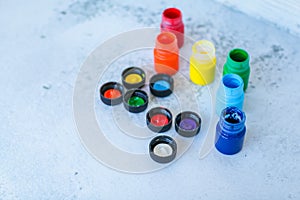 Colorful Gouache or acrylic paints in jars on white grunge background, selective focus