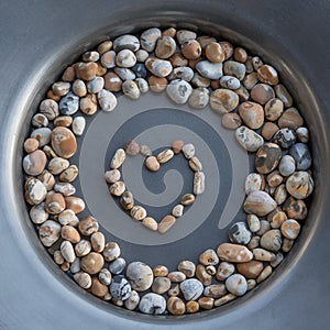 Colorful gravel stones in a corcle with heart in the middle