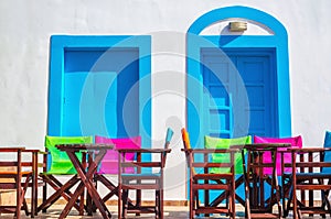 Colorful Greek restaurant table and chairs in front of iconic bl