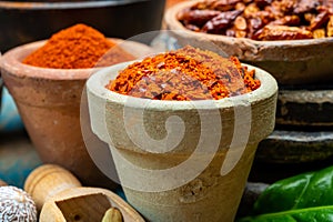 Colorful ground spicy chili peppers , pimento and curcuma is clay pots close up