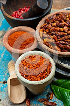 Colorful ground spicy chili peppers , pimento and curcuma is clay pots close up