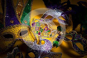 A colorful group of Mardi Gras masks on yellow background