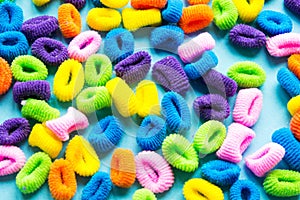 Colorful hair ties on a blue background.