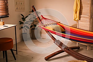 Colorful hammock with pillow in room interior