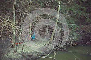 Colorful hammocks hanging on river bank in the woods