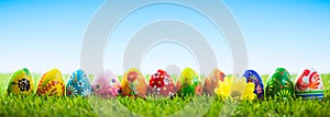 Colorful hand painted Easter eggs on grass. Banner, panoramic