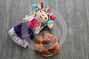 Colorful handmade cloth doll with pan de muerto from the town with sesame in the offering for the Day of the All Souls and All Sai