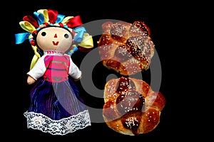 Colorful handmade cloth doll with pan de muerto from the town with sesame in the offering for the Day of the All Souls and All Sai