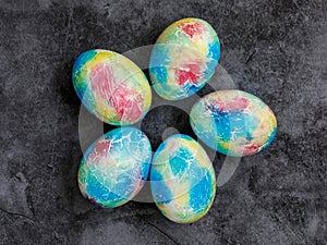 Colorful handmade Easter eggs painted like Earth on black marble background. Minimal happy Easter holiday conceprt. Top