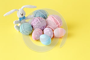 Colorful handmade easter eggs with wool clew and toy rabbit