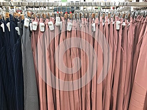 Colorful hanging woman pants on rack, earth tone color