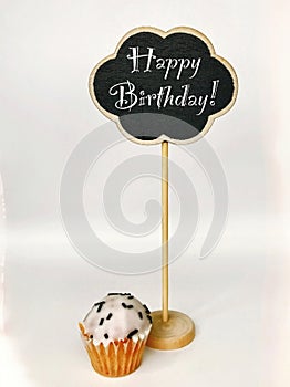 Colorful happy birthday cupcakes with candles with compliments. Birthday cupcake and black board with chalk inscription