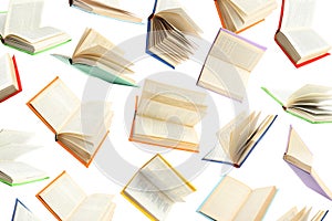 Colorful hardcover books flying on white background