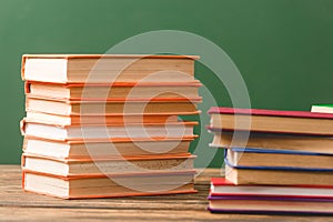 Hardcover books on wooden surface isolated on green