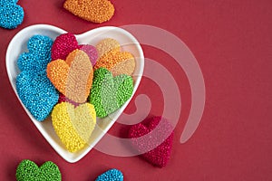 Colorful heart shaped jelly candy sweets isolated on red background