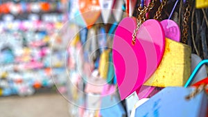 Colorful hearts hanging on wall on the street. Love pink heart shape on blur bokeh background. Copy space
