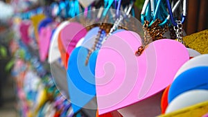 Colorful hearts hanging on wall on the street. Love pink heart shape on blur bokeh background. Copy space