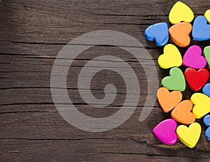 Colorful hearts on wooden background.