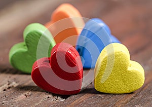 Colorful hearts on wooden background.