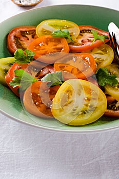 Colorful heirloom tomatoes salad on white