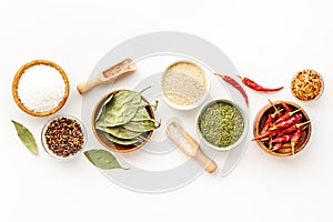Colorful herbs and spices in bowls for cooking. Pepper chili, laurel leaf, salt and curry