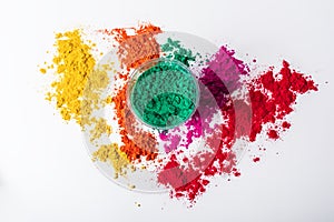 Colorful holi powder in a glass bowl isolated on white background. Top view